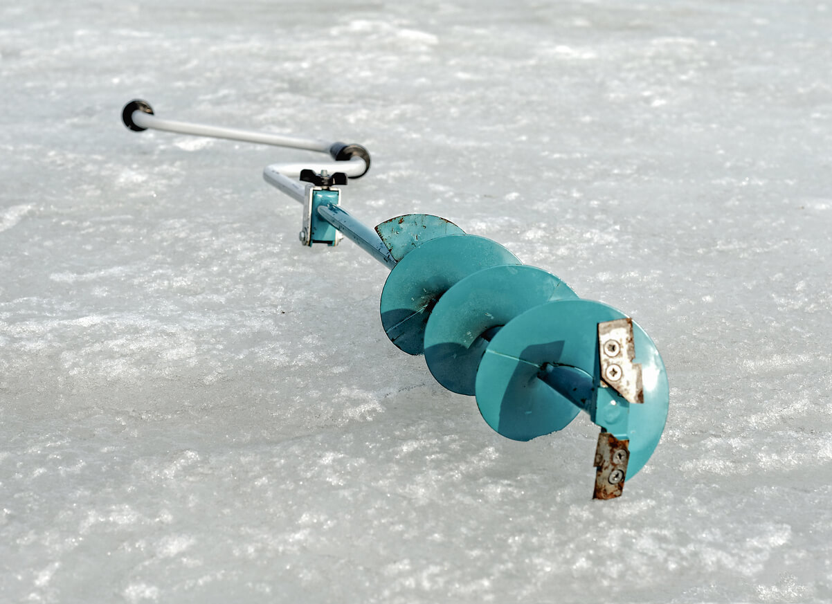 an ice drill laying on ice after using it to check the ice thickness