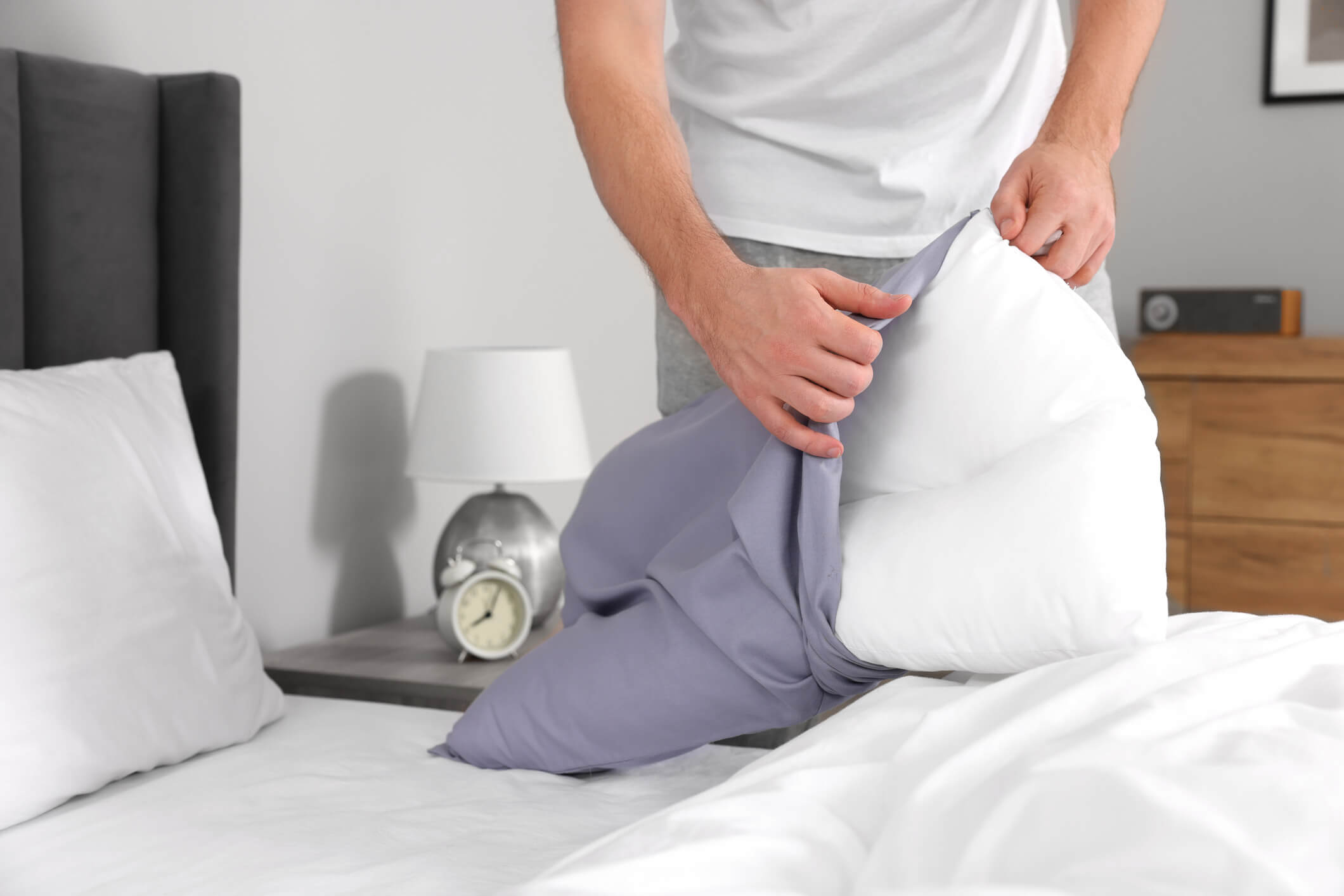 a person putting a pillowcase that was in the fridge on a pillow to stay cool in the heat